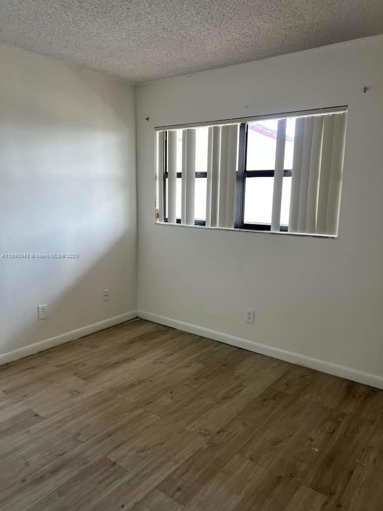3470 Foxcroft Road, Unit 307 Miramar, FL 33025 - Photo 10 of 12 a view of an empty room with wooden floor and a window