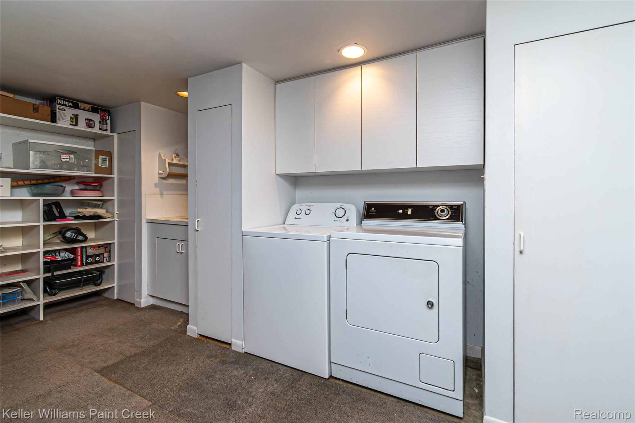 7093 Stonebrook Road West Bloomfield, MI 48322 - Photo 57 of 64 Dedicated laundry area featuring white upper cabinetry, a utility sink with lower cabinetry, and built-in shelving