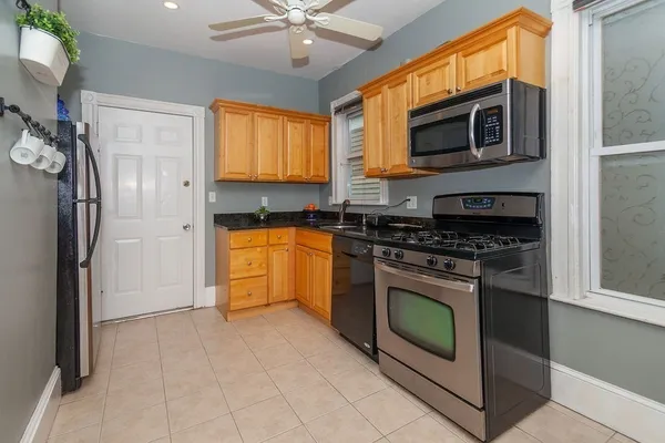 a kitchen with stainless steel appliances granite countertop a stove top oven a refrigerator and a sink