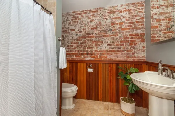 a bathroom with a sink a toilet and shower curtain