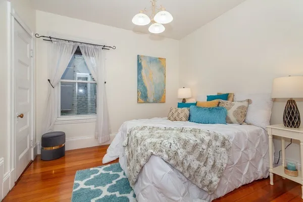 a bedroom with a bed and a chandelier