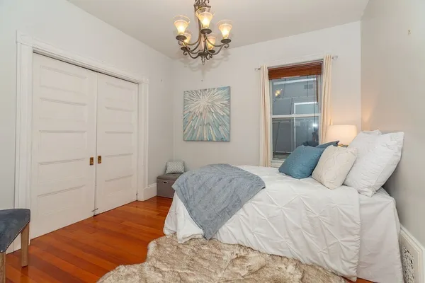 a bedroom with a bed and a chandelier