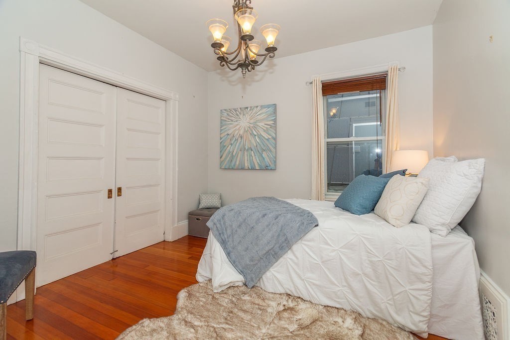 797 Columbia Road, Unit 3 Boston, MA 02125 - Photo 9 of 18 a bedroom with a bed and a chandelier