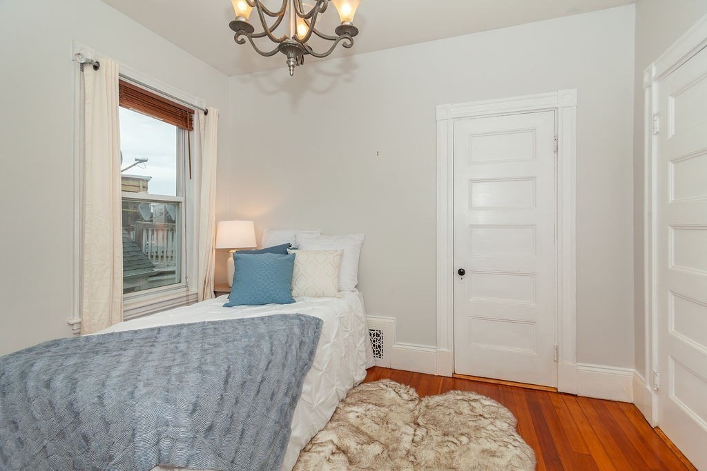 797 Columbia Road, Unit 3 Boston, MA 02125 - Photo 10 of 18 a living room with a couch and a dresser with wooden floor