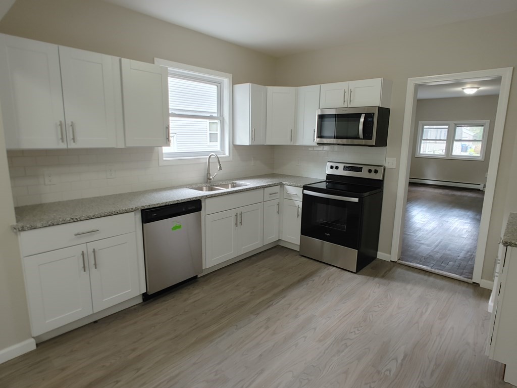 23 Eldert Street Springfield, MA 01109 - Photo 5 of 14 a kitchen with stainless steel appliances granite countertop a stove a sink and a microwave