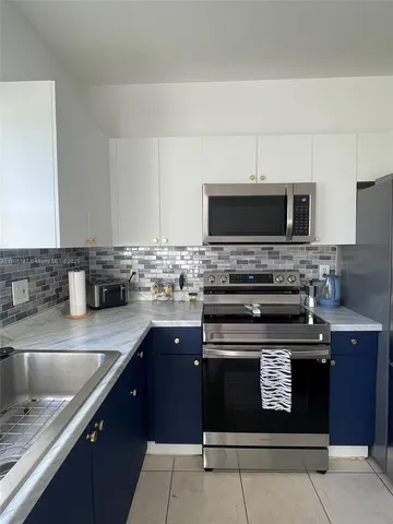 a kitchen with stainless steel appliances granite countertop a stove microwave and sink