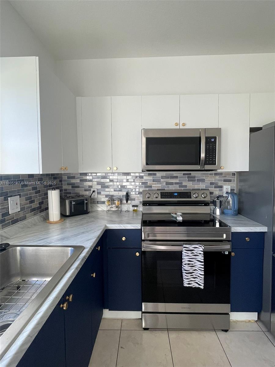 1636 Southeast 30th Street, Unit 1636 Homestead, FL 33035 - Photo 6 of 12 a kitchen with stainless steel appliances granite countertop a stove microwave and sink