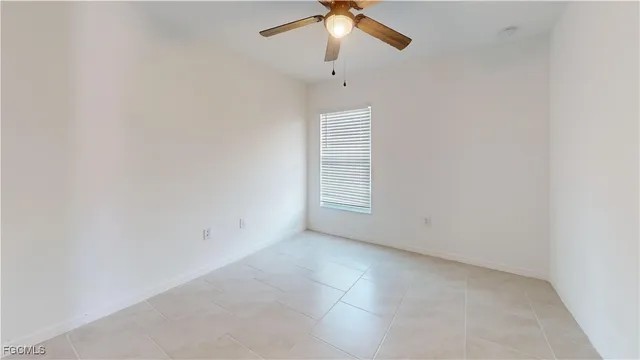an empty room with a window and a fan