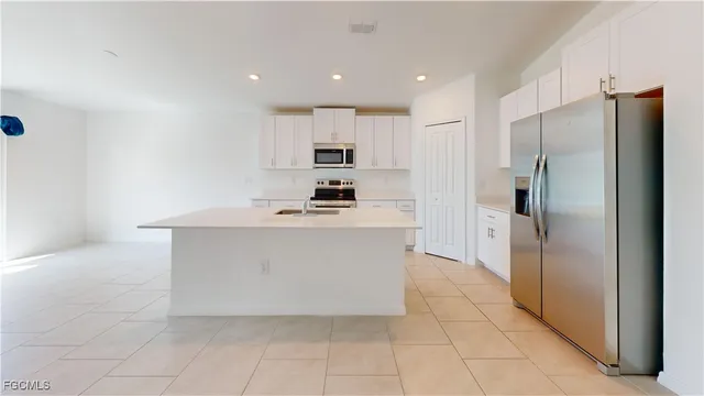 a kitchen with stainless steel appliances a refrigerator sink and cabinets