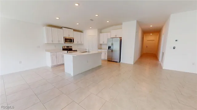 a view of kitchen with stainless steel appliances refrigerator stove microwave and cabinets