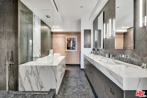 a spacious bathroom with a bathtub shower sink and mirror