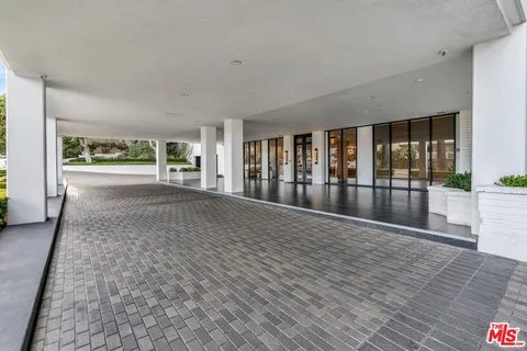 a large living room with stainless steel appliances kitchen island granite countertop a couch a dining table and chairs