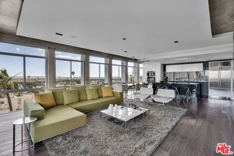 a living room with couches and a dining table with kitchen view