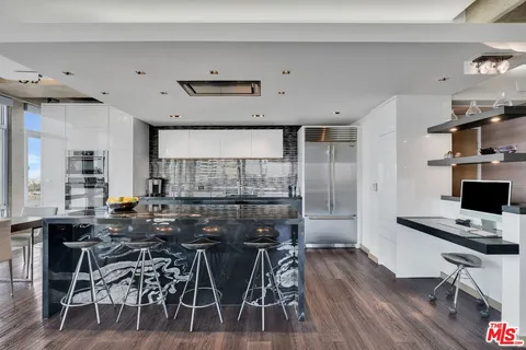 a kitchen with stainless steel appliances a table chairs and a refrigerator