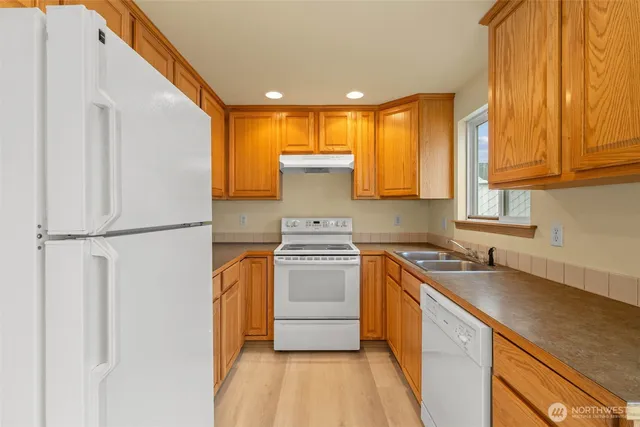 a kitchen with a stove a sink and a refrigerator