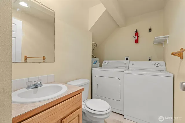 a bathroom with a toilet sink vanity and mirror