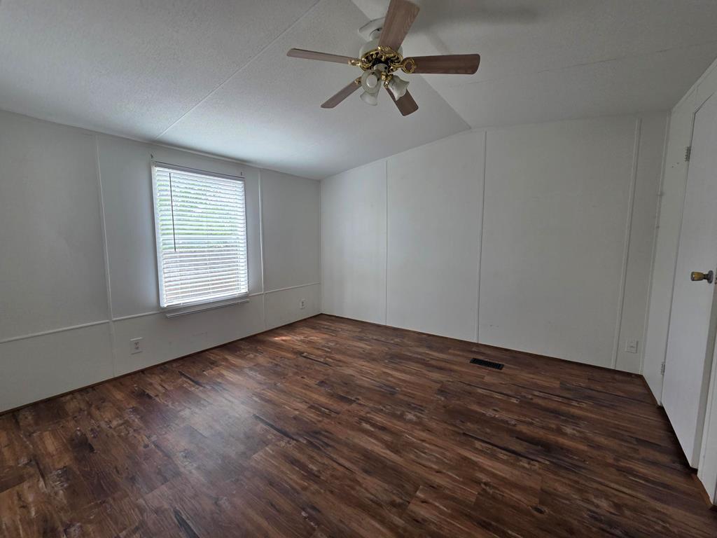 167-6 Beaumont Street Bandera, TX 78003 - Photo 2 of 10 wooden floor in an empty room with a window