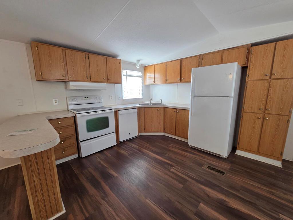167-6 Beaumont Street Bandera, TX 78003 - Photo 5 of 10 a kitchen with a refrigerator sink and cabinets