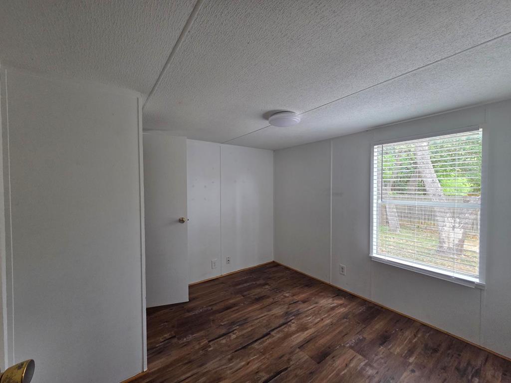 167-6 Beaumont Street Bandera, TX 78003 - Photo 6 of 10 a view of an empty room with wooden floor and a window