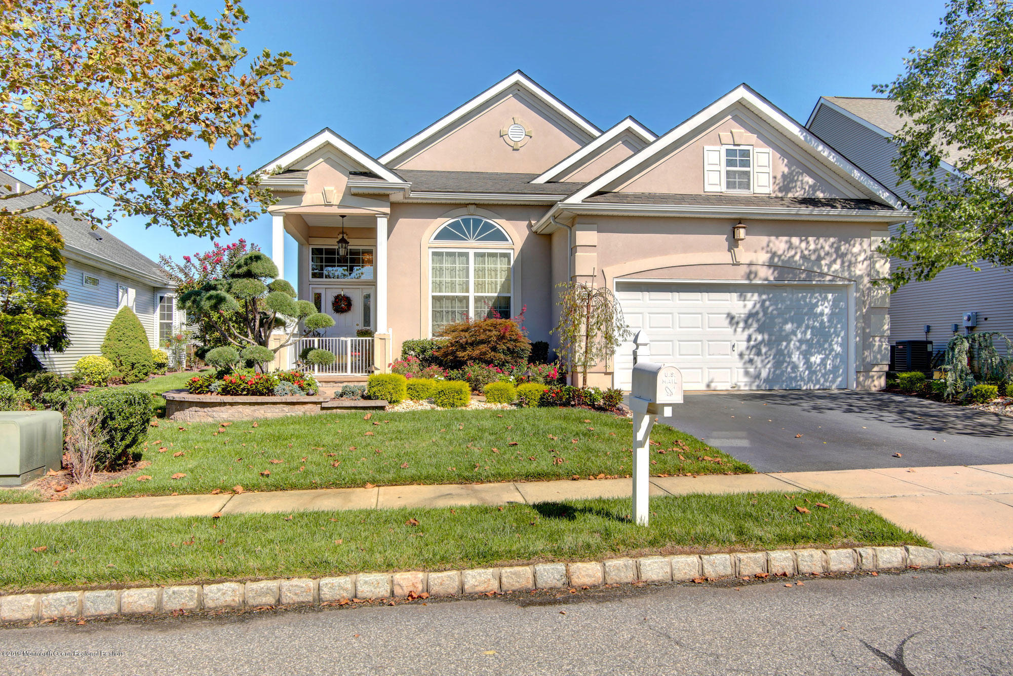a front view of a house with a garden and plants