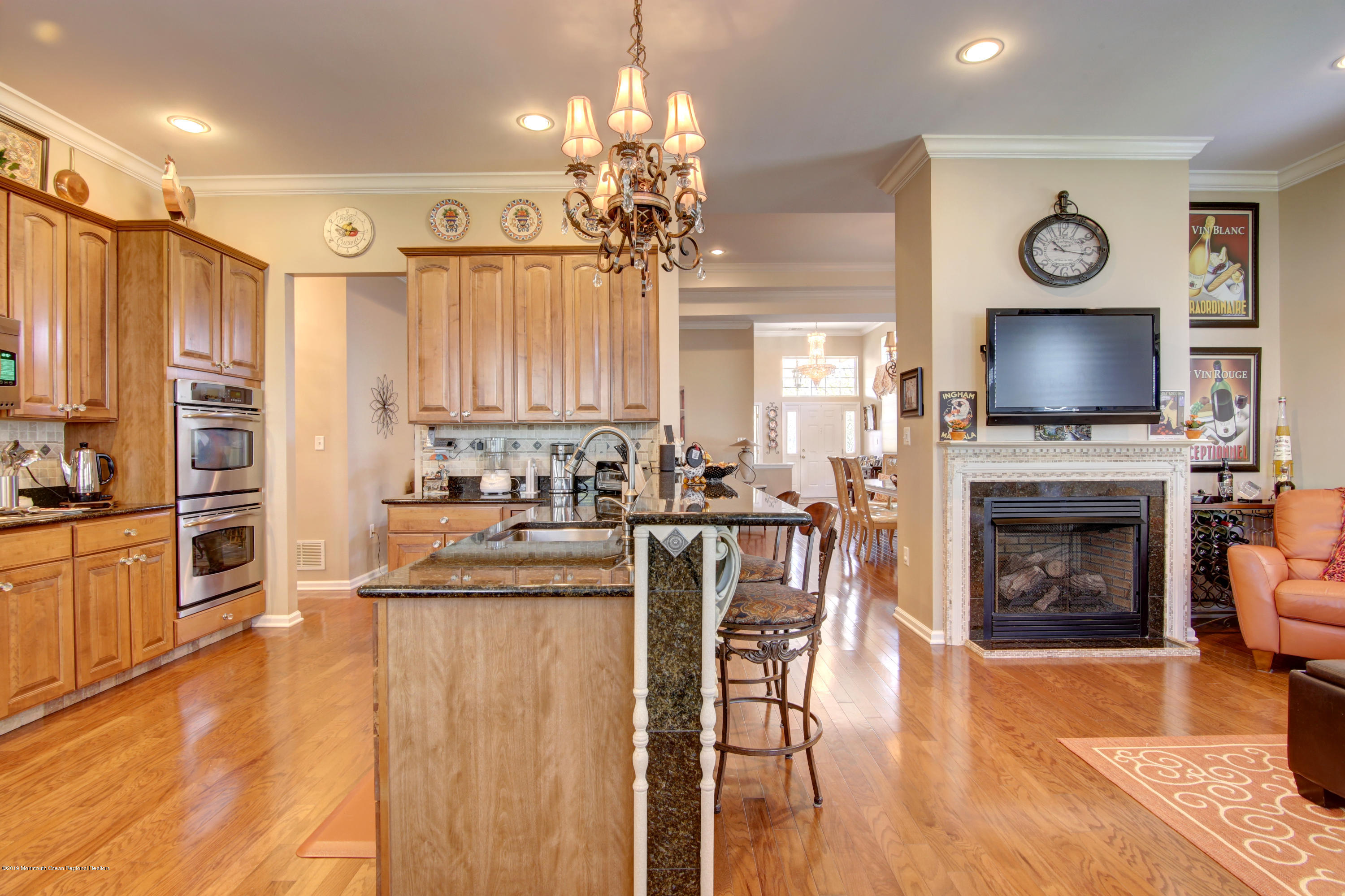 25 Hartack Road Manalapan, NJ 07726 - Photo 4 of 20 a kitchen with stainless steel appliances granite countertop a stove top oven a sink dishwasher a dining table and chairs with wooden floor