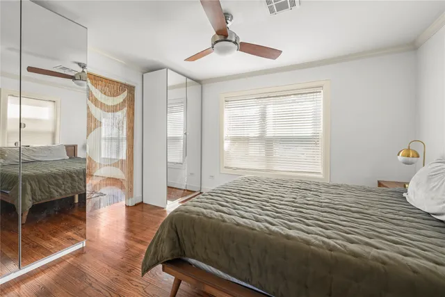 a bedroom with a bed a chandelier and a window