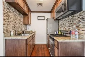 a kitchen with stainless steel appliances granite countertop a sink stove and refrigerator