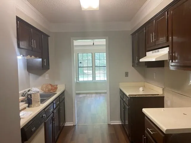 a kitchen with a sink stove top oven and cabinets