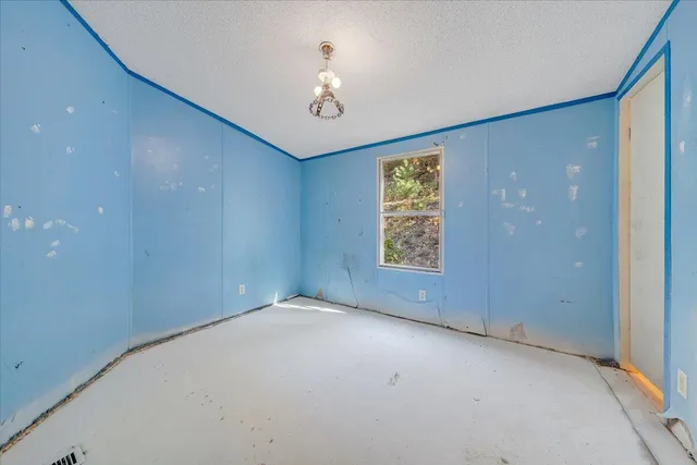 en empty room with windows and chandelier