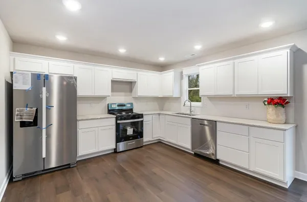 a kitchen with granite countertop white cabinets and stainless steel appliances