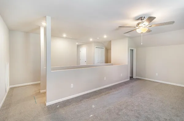 a view of an empty room with a ceiling fan