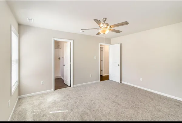 a view of a big room with a ceiling fan and entryway