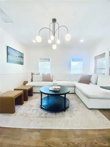 a living room with couches and kitchen view