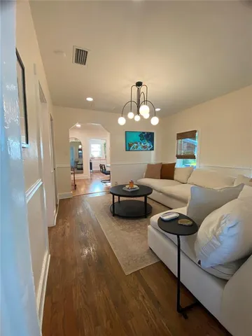 a living room with furniture and a chandelier