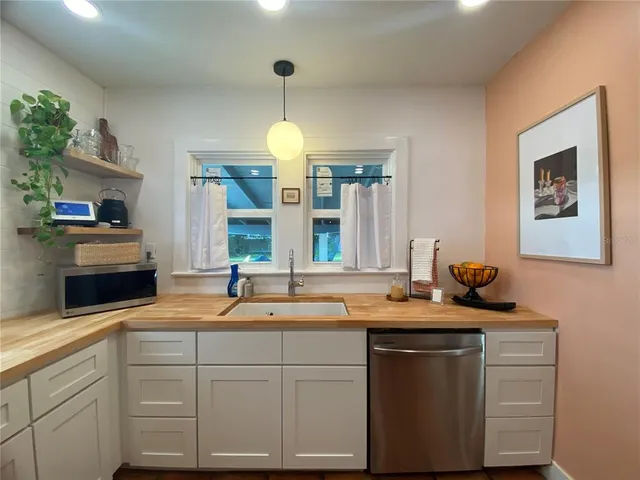 a kitchen with sink and white cabinets