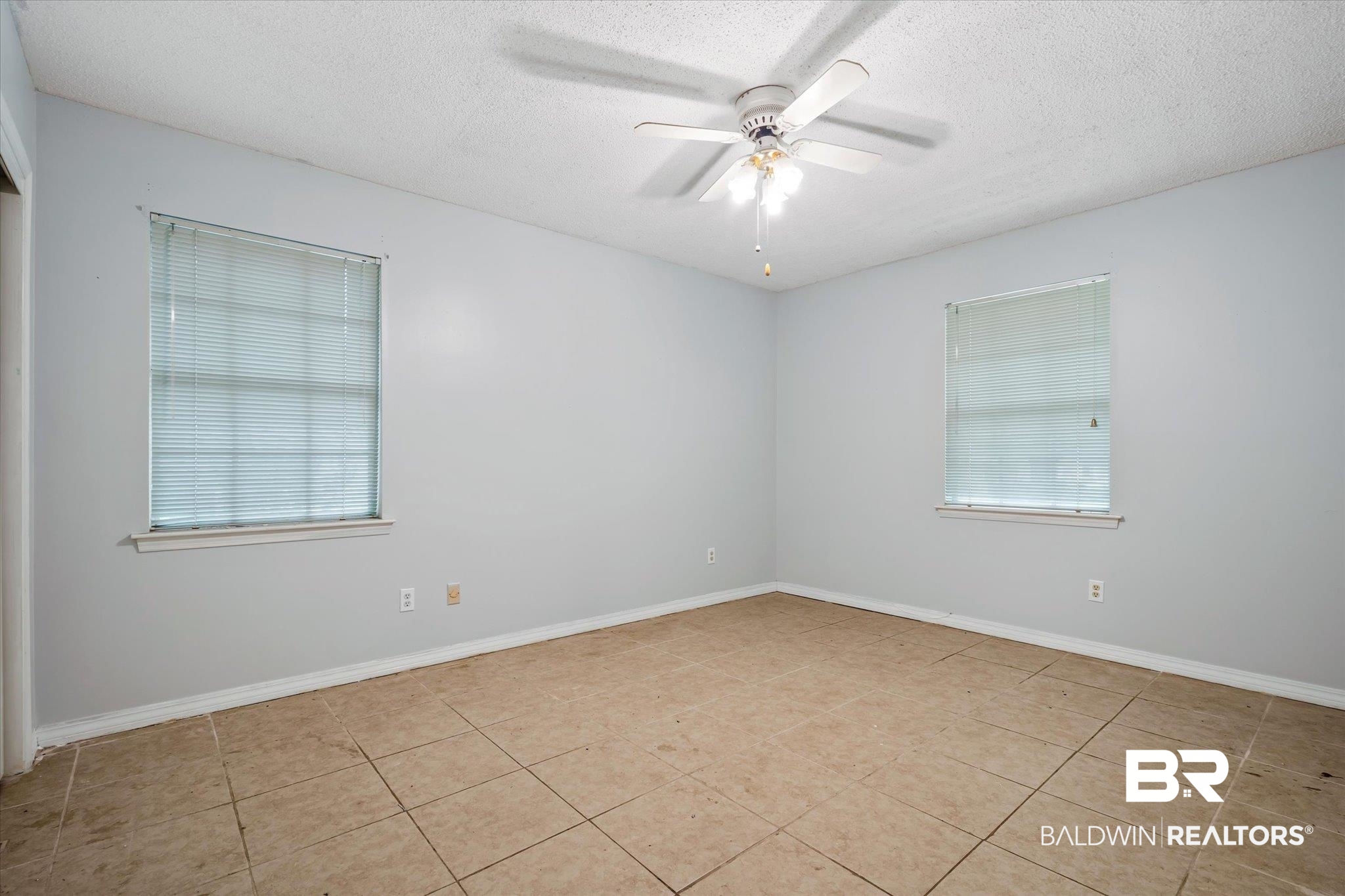 6657 Hounds Run South Mobile, AL 36608 - Photo 13 of 20 Unfurnished room featuring a wealth of natural light, ceiling fan, light tile patterned flooring, and a textured ceiling