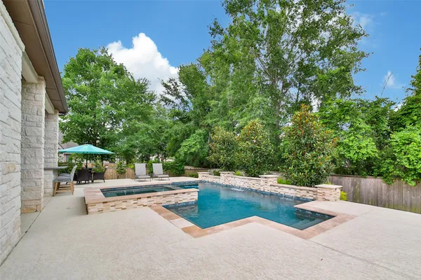 a dining room with stainless steel appliances kitchen island granite countertop a dining table chairs and a refrigerator