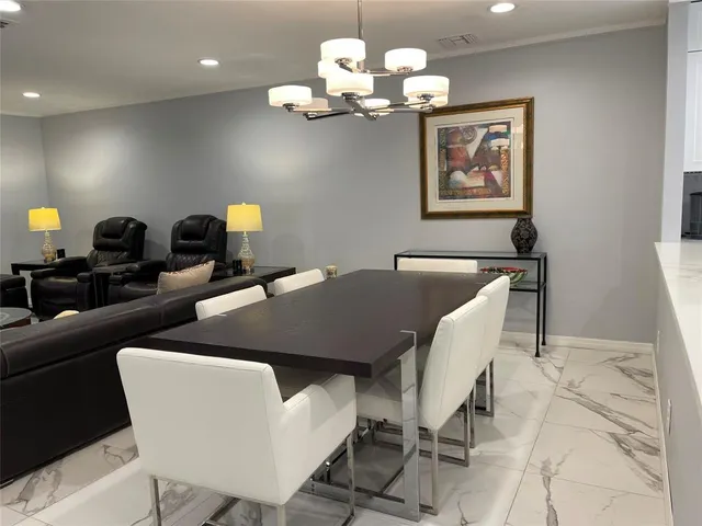 a view of a dining room with furniture and chandelier