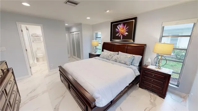 a bedroom with a bed and a painting on the wall