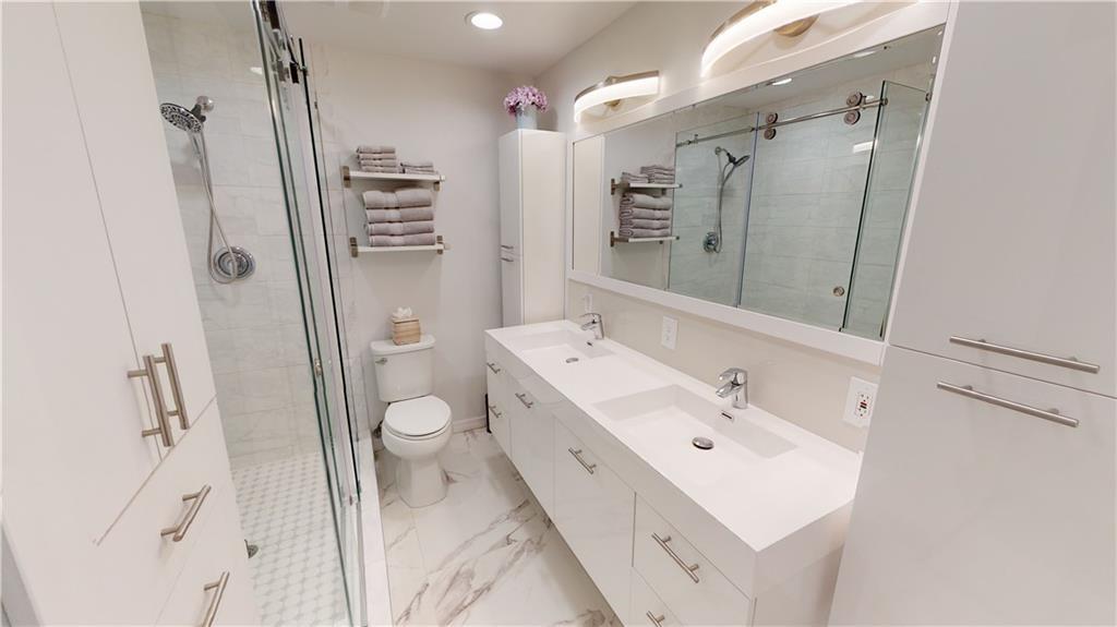 5388 Privet Place, Unit A Delray Beach, FL 33484 - Photo 9 of 33 a spacious bathroom with a double vanity sink toilet and shower
