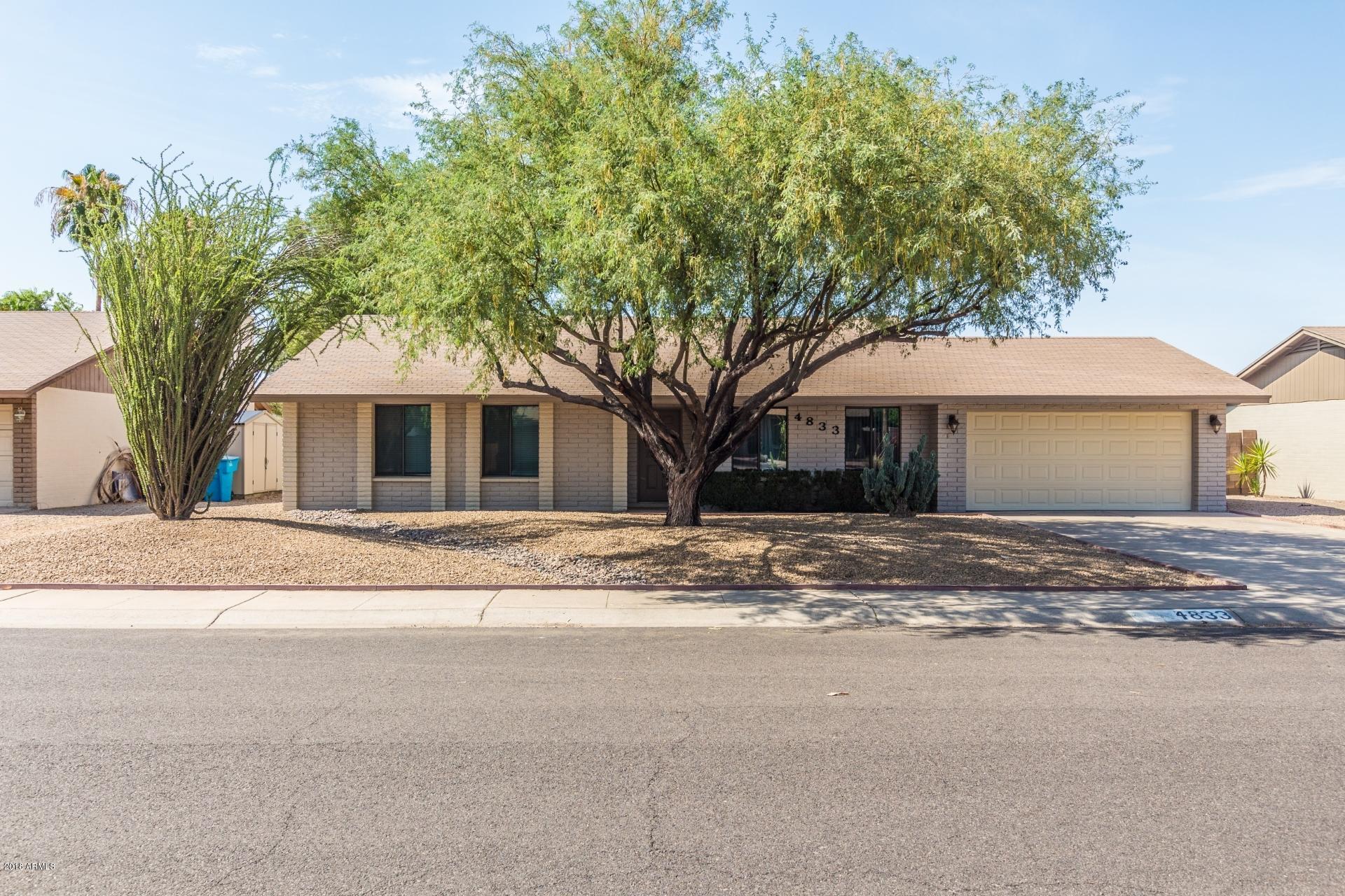a view of a house with a tree in front of it