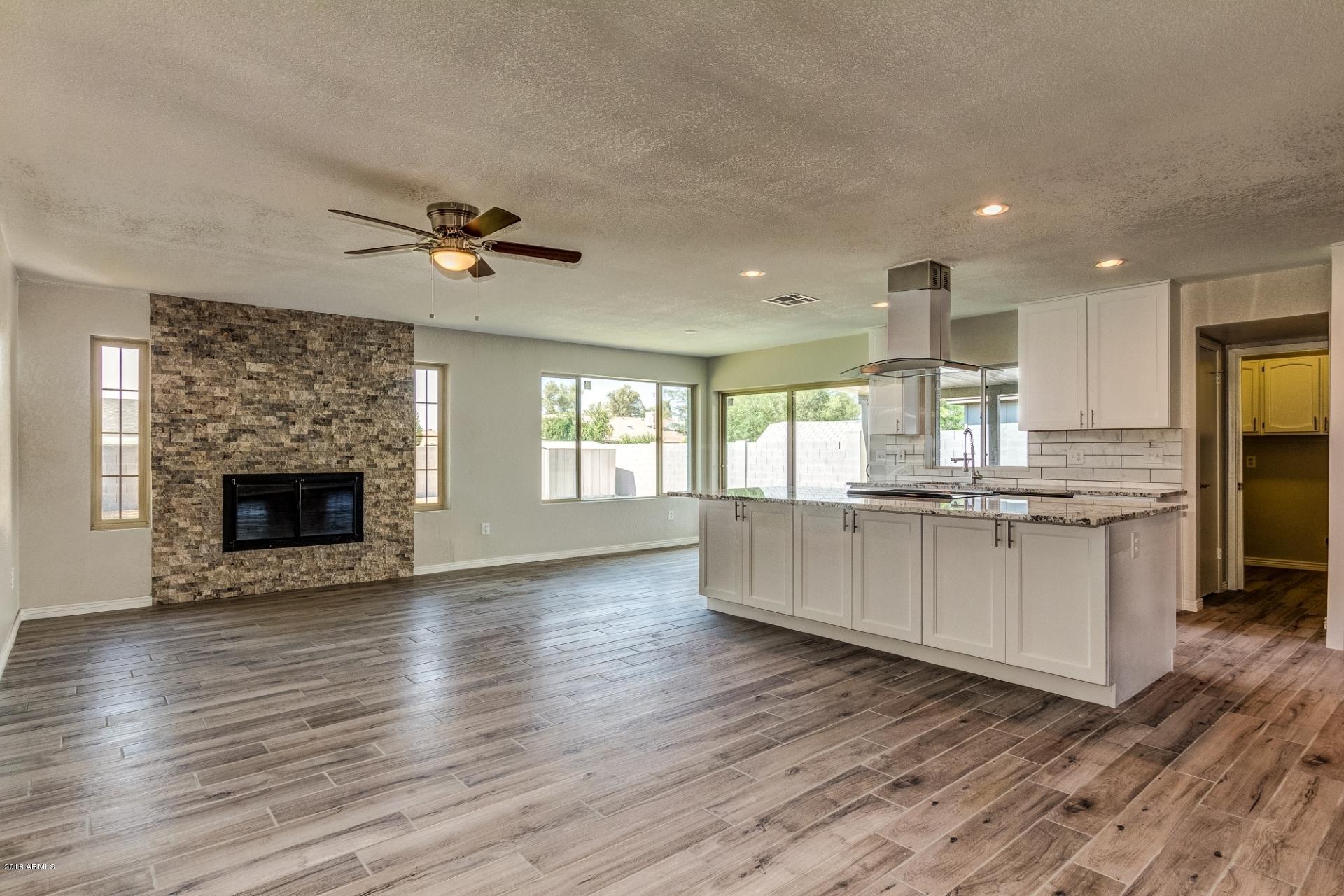 4833 East Kathleen Road Scottsdale, AZ 85254 - Photo 11 of 21 a large kitchen with cabinets wooden floor and a fireplace