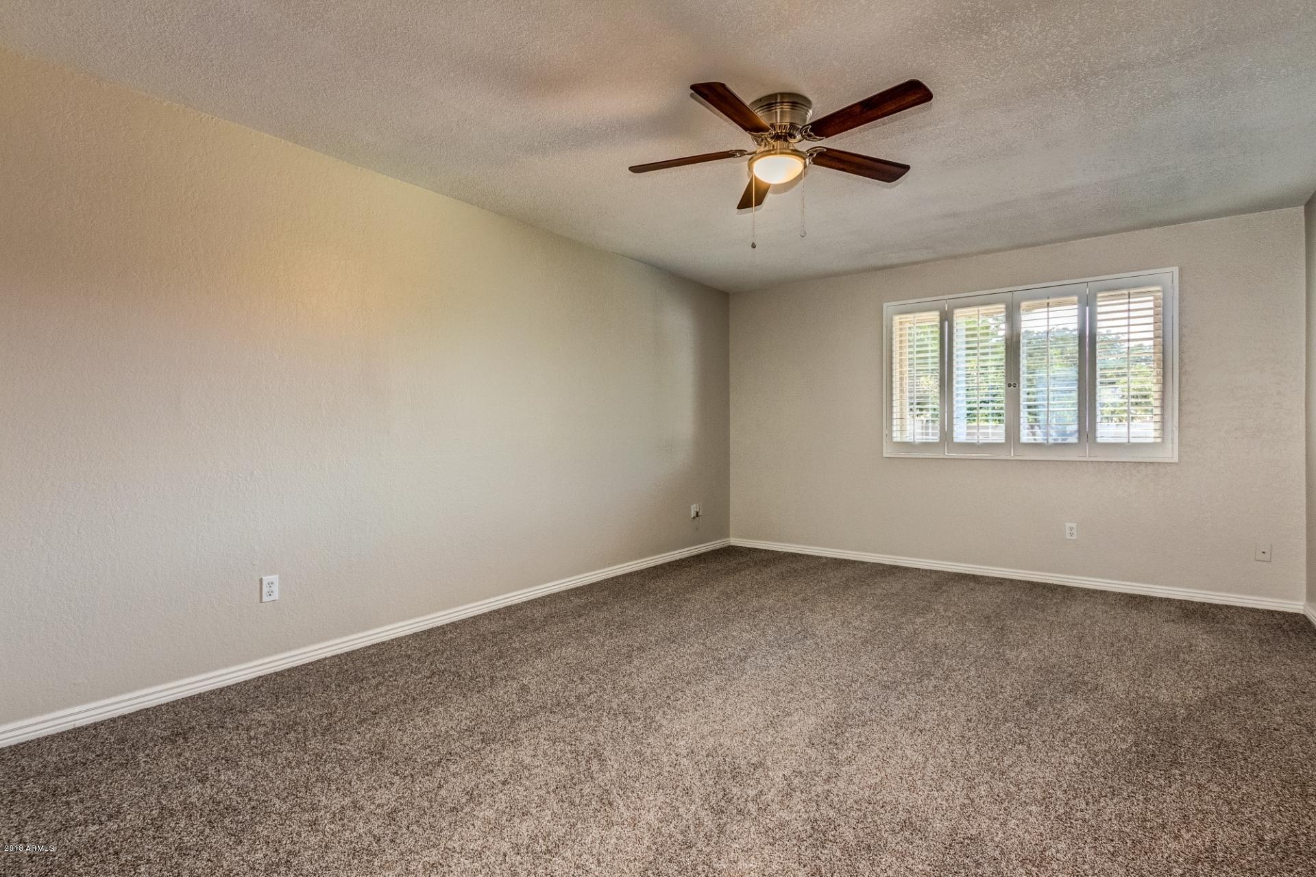 4833 East Kathleen Road Scottsdale, AZ 85254 - Photo 15 of 21 an empty room with windows and ceiling fan