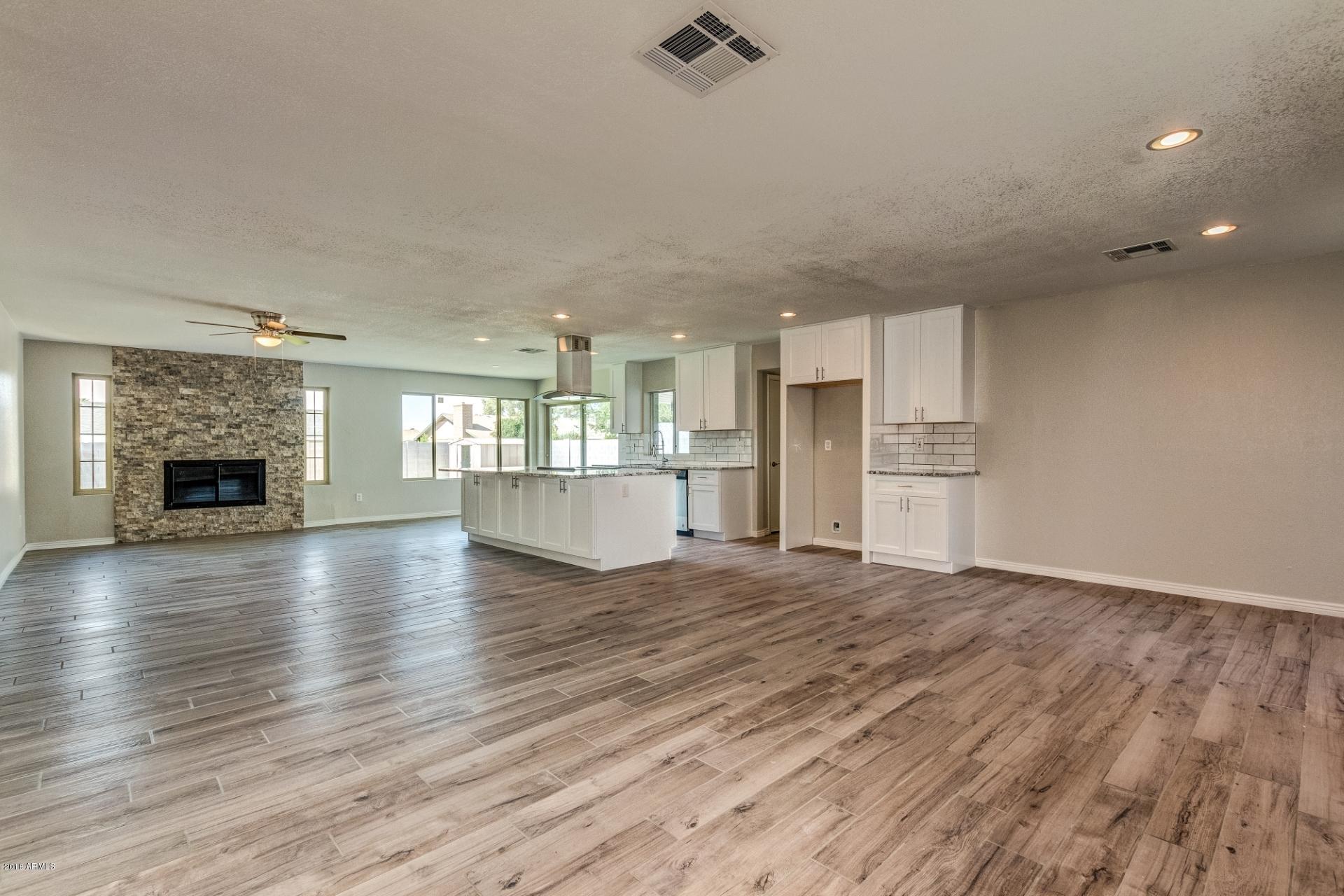 4833 East Kathleen Road Scottsdale, AZ 85254 - Photo 3 of 21 a view of empty room with wooden floor and fireplace