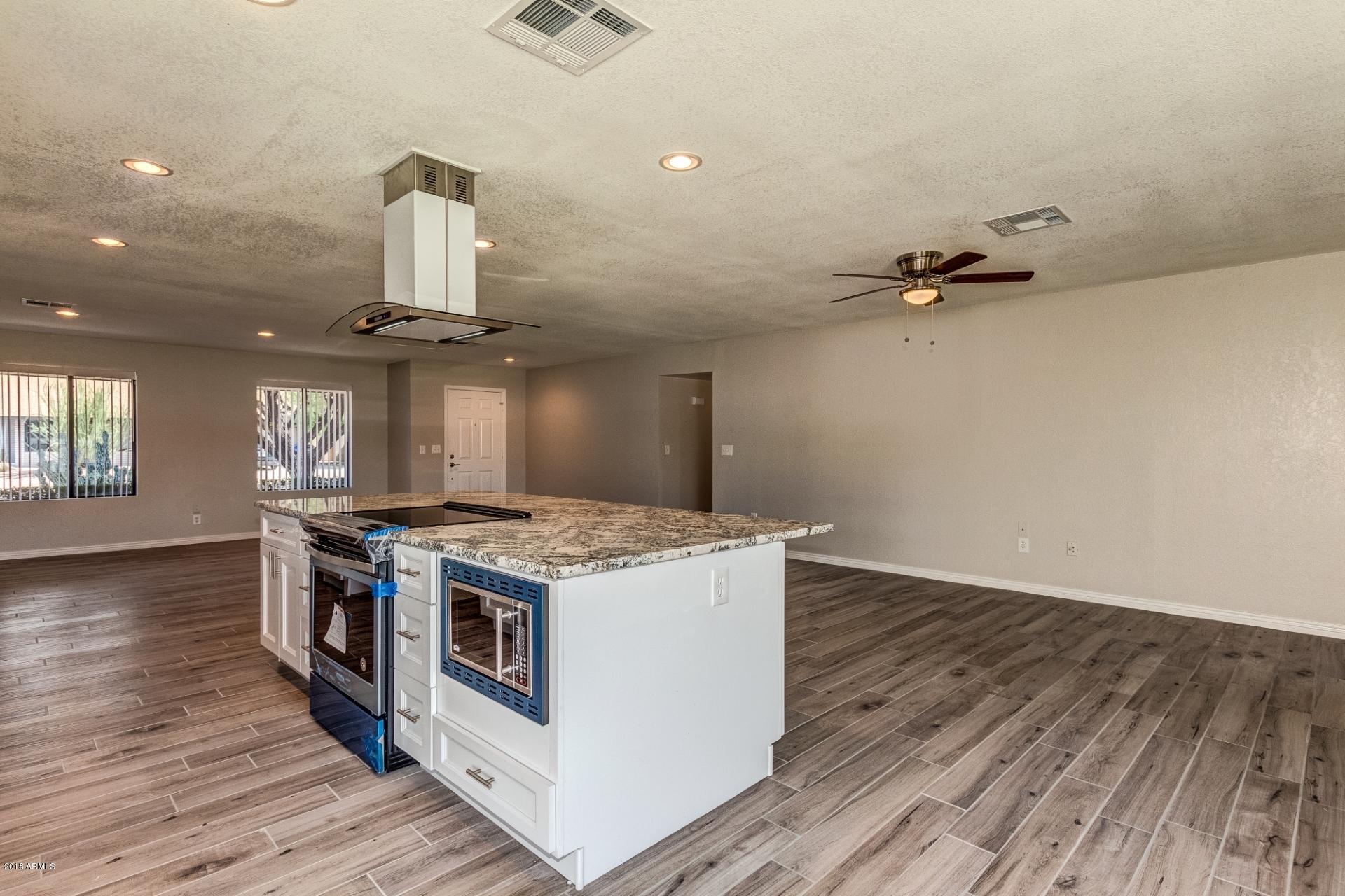 4833 East Kathleen Road Scottsdale, AZ 85254 - Photo 7 of 21 a kitchen with a stove and a wooden floor