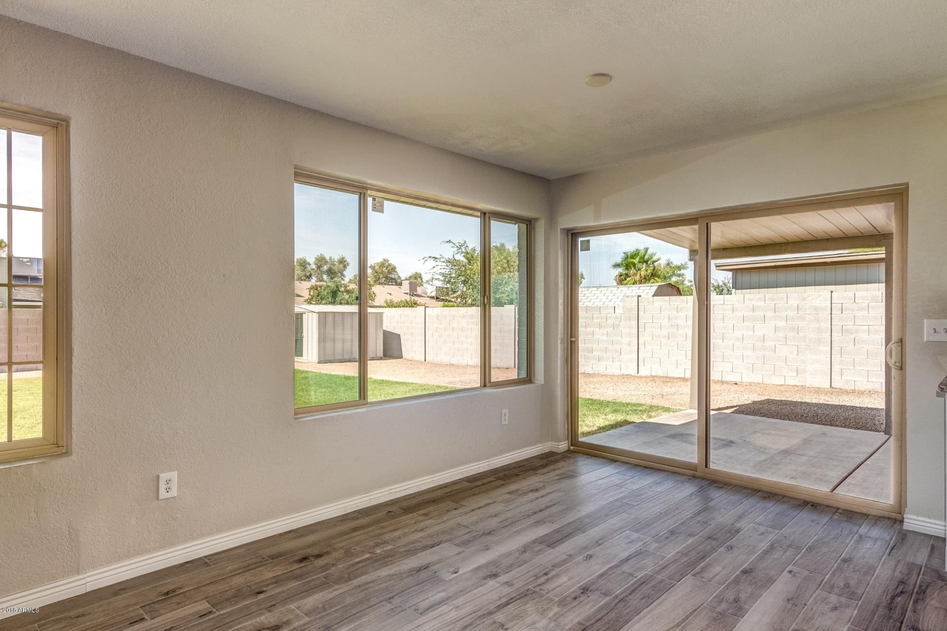 4833 East Kathleen Road Scottsdale, AZ 85254 - Photo 10 of 21 a view of an empty room with wooden floor and a window