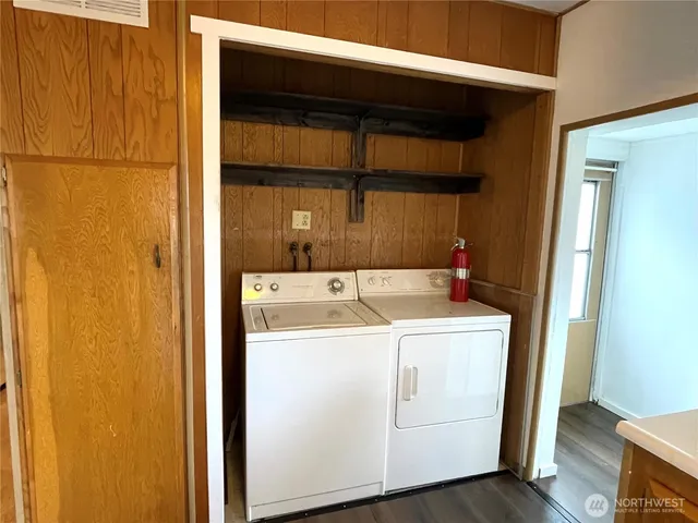 a view of a kitchen with a fridge and wooden floor