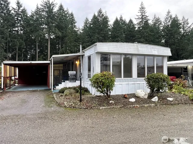 a front view of a house with a yard and potted plants