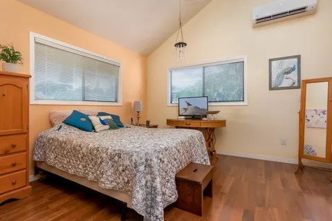 a bedroom with a bed and wooden floor