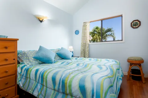 a bedroom with a bed and a painting on the wall